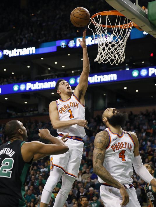 Pebasket Phoenix Suns, Devin Booker, berusaha memasukkan bola saat pertandingan melawan Boston Celtics pada laga NBA di Stadion TD Garden, Boston Minggu (3/12/2017). Boston Celtics menang 116-111 atas Phoenix Suns. (AP/Michael Dwyer)