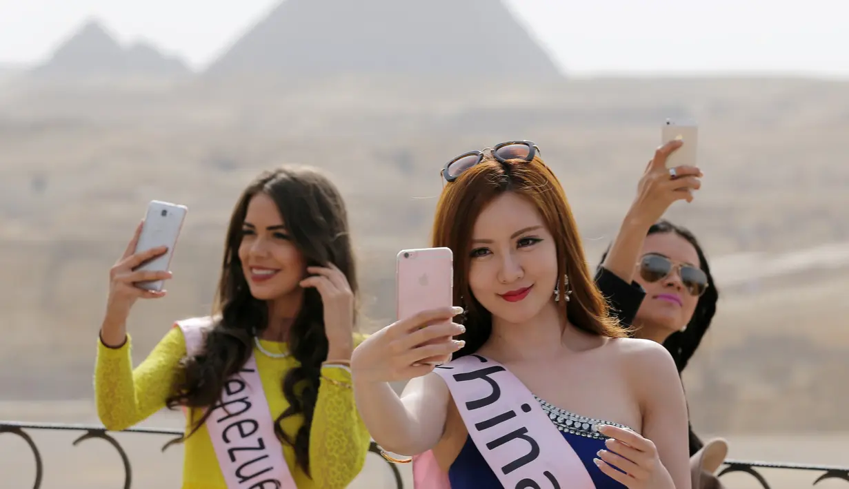 Senyum manis Miss ECO Universe asal China berselfie dengan latar segitiga Piramida, Kairo, Mesir (10/4). Pemenang Miss Eco Universe 2016 akan menerima selempang dan mahkota dari Miss ECO 2015 Patricia Peklar dari Slovenia. (REUTERS/Mohamed Abd El Ghany)