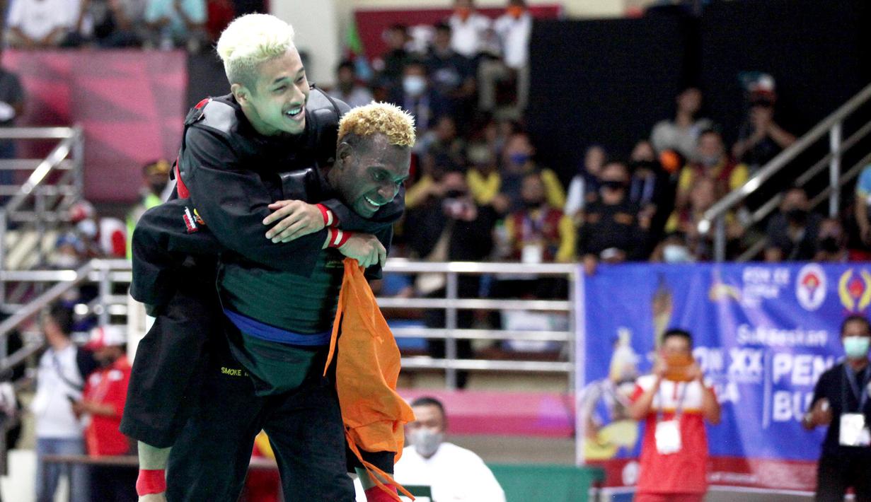 Atlit Pencak Silat dari Jawa Barat Hanifan Yudanin Kusumah digendong Tiel Taraipos dari Papua, setelah Hanifan berhasil mengalahkan Tiel di kelas D Putra  pada PON XX PAPUA  di GOR Toware (12/10) Jayapura. (FOTO; PB PON XX PAPUA/TATAN AGUS RUSTANDI)