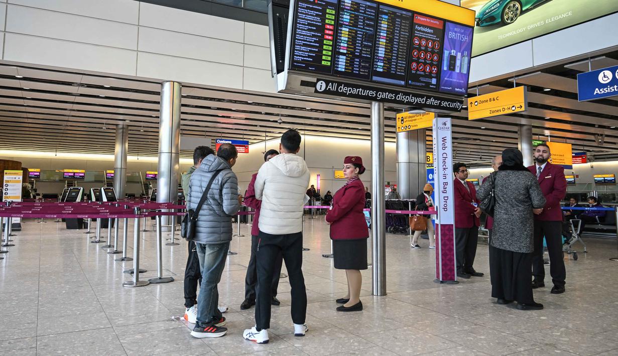 Sejumlah penerbangan jarak jauh yang biasanya singgah di Dubai kemungkinan akan dialihkan, ditunda, atau dibatalkan sepenuhnya. Tampak dalam foto, staf dari Qatar Airways membantu menjawab pertanyaan orang-orang di area check-in yang kosong di Bandara Heathrow, London pada Minggu 1 Maret 2026. (JUSTIN TALLIS/AFP)