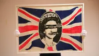 "God Save the Queen" karya seniman Inggris Jamie Reid, sebuah poster promosi, milik Sid Vicious, dipajang di London pada 12 Oktober 2022, sebagai bagian dari memorabilia Koleksi Sex Pistols Stolper-Wilson, yang akan dilelang di Sotheby's di London pada 21 Oktober 2022. Koleksi tersebut dikumpulkan oleh dealer seni kontemporer Paul Stolper dan kritikus, sejarawan Andrew Wilson. Ini meneliti bagaimana Sex Pistols berhasil menjungkirbalikkan dunia musik dan budaya visual di bawah manajer mereka Malcolm McLaren, yang menganggap band sebagai bagian dari karya seni yang hidup. (DANIEL LEAL / AFP)