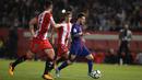 Bintang Barcelona, Lionel Messi, berusaha melewati bek Girona, Juanpe Ramirez, pada laga La Liga Spanyol di Stadion Montilivi, Girona, Sabtu (23/9/2017). Girona kalah 0-3 dari Barcelona. (AFP/Josep Lago)