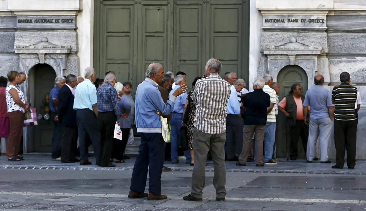 Sejumlah pensiunan berdiri di depan kantor pusat Bank Nasional Yunani di Athena, (29/6/2015). Krisis keuangan Yunani yang terjadi sejak 2009, membuat pemerintah setempat dan bank sentral membuat berbagai kebijakan. (REUTERS/Alkis Konstantinidis)
