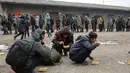 Sejumlah imigran mengantre untuk mendapatkan makanan di gudang tak terpakai di Belgrade, Serbia, Kamis (22/12). (REUTERS / Marko Djurica)