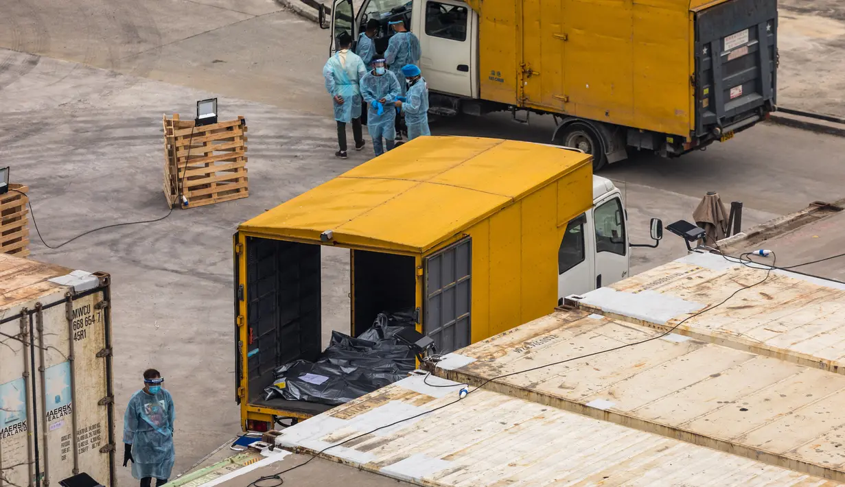 Pekerja bersiap memindahkan jenazah dari truk ke kontainer berpendingin di Rumah Sakit Umum Fu Shan, Hong Kong, Rabu (16/3/2022). Kasus COVID-19 terburuk yang melanda Hong Kong menimbulkan kepanikan serta membuat rumah sakit dan kamar jenazah penuh. (DALE DE LA REY/AFP)