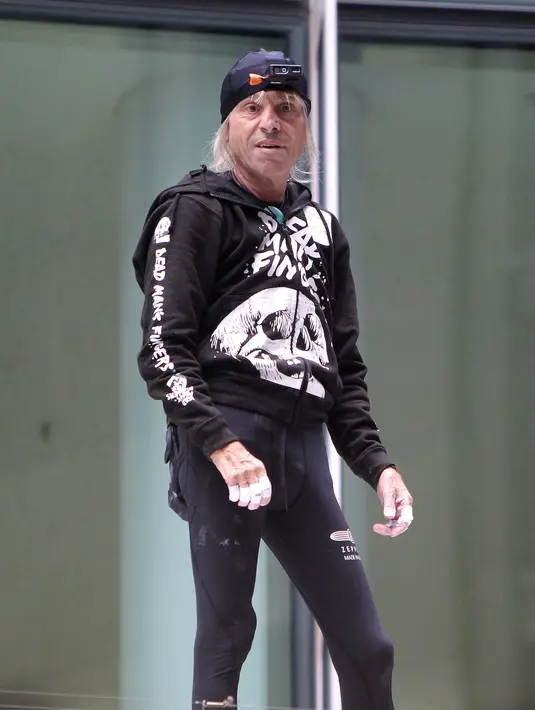 Pendaki kota Prancis, Alain Robert berpose saat memanjat gedung XYZ di Frankfurt am Main, Sabtu (28/9/2019). Pria berusia 56 tahun itu memanjat gedung XYZ tanpa peralatan keselamatan. (AFP Photo/Daniel Roland)