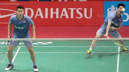 Kevin Sanjaya (kanan) melepaskan smash ke arah Rian Agung/Hendra Setiawan pada babak kedua Daihatsu Indonesia Master 2018 di Istora Senayan, Kamis (25/1/2018). Kevin/Marcus menang 21-16 23-2.1 (Bola.com/Nick Hanoatubun)