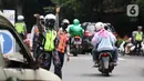 Petugas memberhentikan kendaraan roda empat saat uji coba ganjil-genap di Jalan Margonda Raya, Depok, Jawa Barat, Minggu (5/12/2021). Polres Metro Kota Depok bersama Dishub menyiapkan enam pos pemeriksaan dalam melaksanakan uji coba penerapan ganjil-genap (gage). (Liputan6.com/Herman Zakharia)