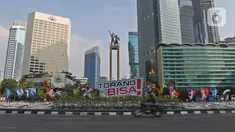 Pengendara sepeda motor melintas di dekat maskot Pekan Olahraga Nasional (PON) XX Papua di Bundaran Hotel Indonesia, Jakarta, Jumat (16/07/2021). Pemasangan maskot PON XX Papua itu bentuk promosi kegiatan pekan olahraga yang diselenggarakan tiap empat tahun sekali. (Liputan6.com/Herman Zakharia)