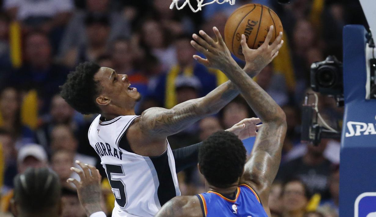 Pebasket San Antonio Spurs, Dejounte Murray, berusaha memasukan bola saat pertandingan melawan Oklahoma City Thunder pada laga NBA di Chesapeake Energy Arena, Minggu (11/3/2018). Thunder menang 104-94 atas Spurs. (AP/Sue Ogrocki)