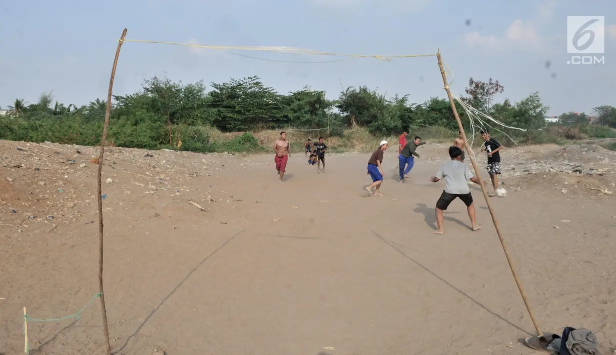 Anak-anak saat bermain sepakbola di tanah sengketa kawasan Pedongkelan, Jakarta, Kamis (11/7/2019). Meski bertempat tinggal di atas lahan sengketa, anak-anak setempat memanfaatkan tanah kosong yang penuh semak belukar tersebut sebagai sarana bermain ketika sore hari. (merdeka.com/Iqbal S. Nugroho)