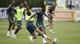 Fred (kanan) saat di jegal rekannya Casemiro pada sesi latihan di lapangan latihan Tottenham Hotspur football club, Inggris, (7/6/2018). Fred mengalami masalah di engkel kaki. (AP/Matt Dunham)