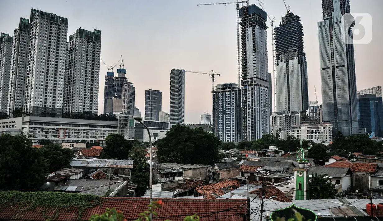 Suasana kawasan permukiman penduduk dengan latar belakang gedung pencakar langit di Jakarta, Kamis (26/8/2021). Defisit APBN terjadi karena hingga akhir Juli pendapatan negara baru mencapai Rp1.031,5 triliun atau 59,2 persen dari target yakni Rp 1.743,6 triliun. (merdeka.com/Iqbal S Nugroho)