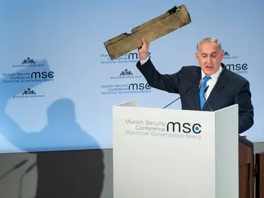 Perdana Menteri Israel Benjamin Netanyahu menunjukkan benda yang diduga potongan pesawat tak berawak Iran yang ditembak jatuh di wilayah Israel saat pidato dalam Konferensi Keamanan Munich (18/2). (AFP/ MSC Munich Security Conference / Lennart Preiss)