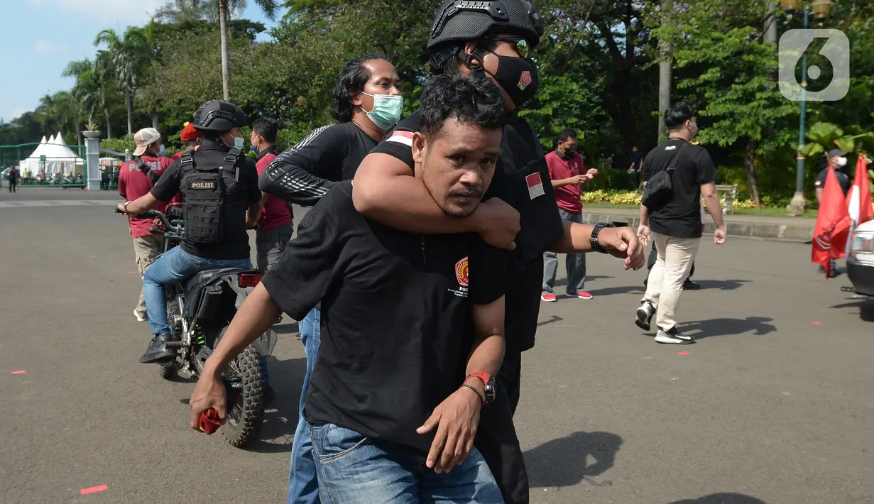 Aparat kepolisian mengamankan seorang pria saat unjuk rasa memperingati May Day atau Hari Buruh di kawasan Patung Kuda, Jakarta, Sabtu (1/5/2021). Polisi mengamankan sejumlah massa yang diduga mahasiswa dalam aksi unjuk rasa tersebut. (merdeka.com/Imam Buhori)