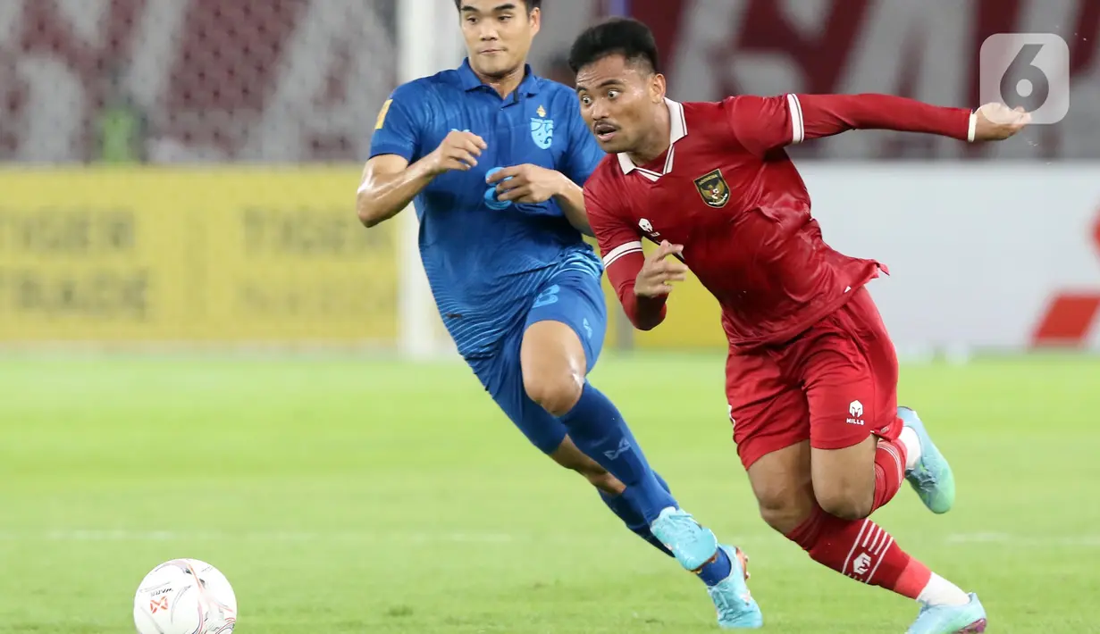 Pemain tengah timnas Indonesia, Saddil Ramdhani (kanan) berebut bola dengan Peeradoi Chamrasamee (Thailand) pada lanjutan kualifikasi Grup A Piala AFF 2022 di Stadion Utama Gelora Bung Karno, Jakarta, Kamis (29/12/2022). Laga berakhir imbang 1-1. (Liputan6.com/Helmi Fithriansyah)