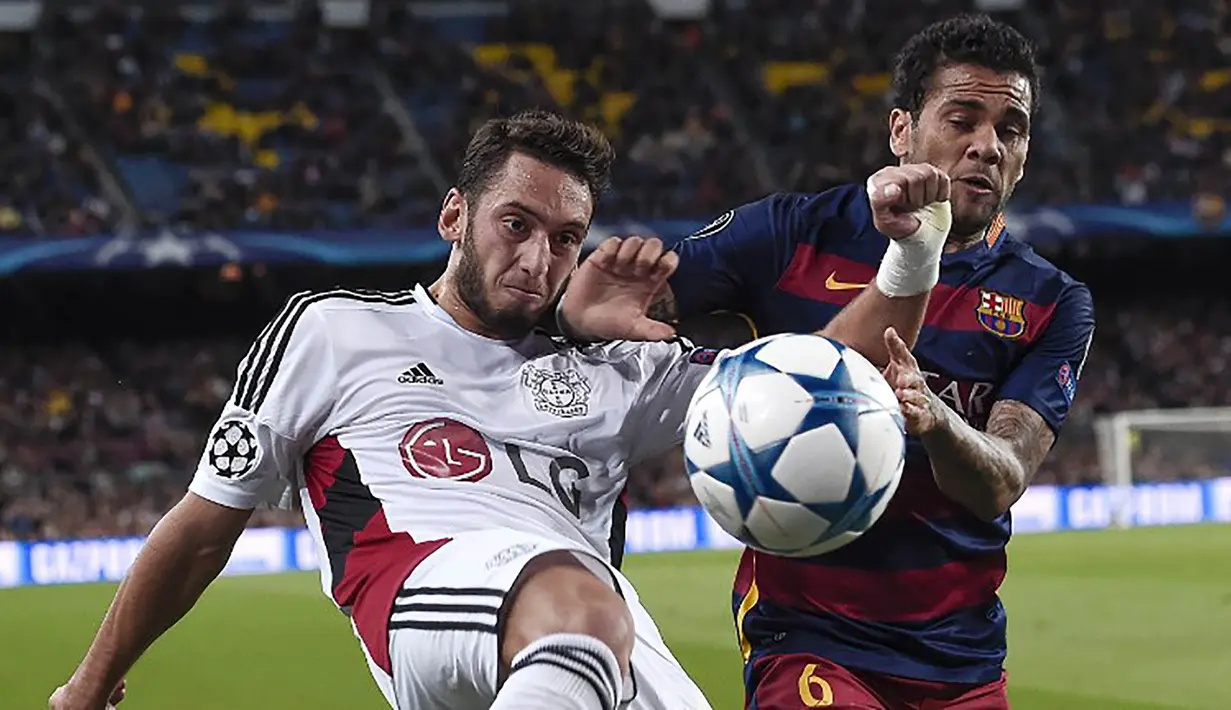 Bek sayap Barcelona, Dani Alves berebut bola dengan gelandang Leverkusen Hakan Calhanoglu pada laga Liga Champions di Stadion Camp Nou, Spanyol, Rabu (30/9/2015). (AFP Photo/Josep Lago)