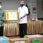 Gubernur Riau Syamsuar menyerahkan penghargaan kepada SEVP Operasional PTPN V Ospin Sembiring karena kepedulian terhadap Covid-19 di Riau. (Liputan6.com/Istimewa)