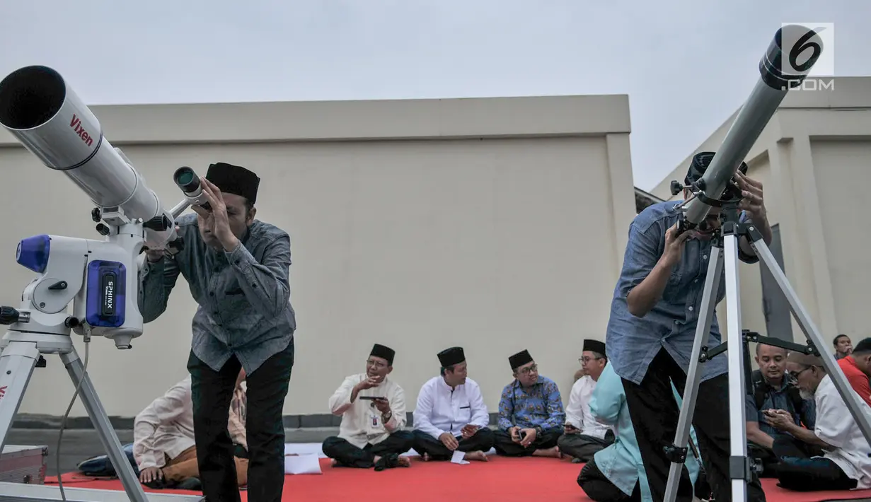 Tim hisab rukyat Kanwil Kemenag DKI Jakarta memantau hilal menggunakan teleskop di atap Gedung Kanwil Kemenag DKI Jakarta, Senin (03/6/2019). Posisi hilal sore ini menurut tim hisab adalah di 0,07 derajat di bawah ufuk, dan tidak terlihat hilal. (merdeka.com/Iqbal S Nugroho)