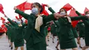 Wanita yang mengenakan masker wajah untuk membantu mengekang penyebaran virus corona COVID-19 berparade dengan bendera saat rapat umum menyambut Kongres ke-8 Partai Buruh Korea di Lapangan Kim Il Sung, Pyongyang, Korea Utara, Senin (12/10/2020). (AP Photo/Jon Chol Jin)
