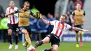 Pemain Arsenal, Theo Walcott (kiri), berebut bola dengan pemain Sunderland, Lee Cattermole, dalam laga Liga Inggris di Stadium of Light, Sunderland, Minggu (24/4/2016) malam WIB. (AFP/Graham Stuart)