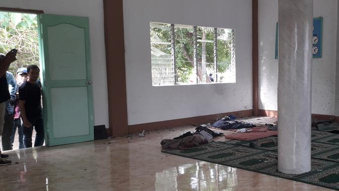 Orang-orang melihat kondisi sebuah masjid setelah serangan granat di Zamboanga, Filipina selatan, Rabu (30/1). Akibat serangan granat tersebut, dua orang tewas dan empat lainnya luka-luka. (Photo by STR / AFP)