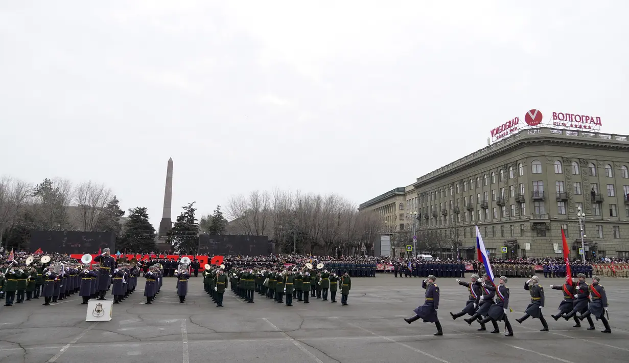 Penjaga kehormatan Rusia berbaris membawa bendera nasional dan replika spanduk Kemenangan selama parade militer yang memperingati 80 tahun kemenangan Soviet pada Pertempuran Stalingrad selama Perang Dunia Kedua, di selatan kota Volgograd pada 2 Februari 2023. (AFP/Stringer)