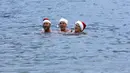 Puluhan anggota klub renang "Berliner Seehunde" merayakan Natal dengan berenang di danau Orankesee, Berlin (25/12/2014). Anggota klub "Berliner Seehunde" bernyanyi saat berenang di danau Orankesee, Berlin. (REUTERS/Fabrizio Bensch)