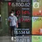 Karyawan melintasi layar yang menampilkan Indeks Harga Saham Gabungan (IHSG) saat acara Penutupan Perdagangan Bursa Efek Indonesia Tahun 2022 di Jakarta, Jumat (30/12/2022). PT Bursa Efek Indonesia (BEI) mencatat ada 59 perusahaan yang melakukan Initial Public Offering (IPO) atau pencatatan saham sepanjang 2022. Pada penutupan perdagangan akhir tahun, Indeks Harga Saham Gabungan (IHSG) ditutup lesu 0,14% atau 9,46 poin menjadi 6.850,62. (Liputan6.com/Angga Yuniar)