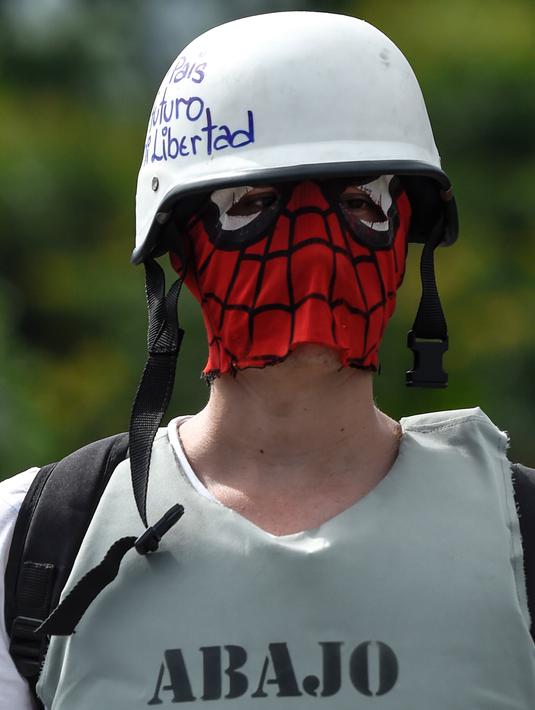 Seorang demonstran menggunakan penutup wajah berkarakter Spider-Man saat unjuk rasa menuntut Presiden Venezuela, Nicolas Maduro mundur, di jalan raya Francisco Fajardo di Caracas, pada 1 Juli 2017. (AFP Photo/Juan Barreto)
