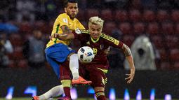Pemain Brasil, Dani Alves, berebut bola dengan pemain Venezuela, Adalberto Penaranda, dalam laga Kualifikasi Piala Dunia 2018 zona Amerika Selatan di Metropolitano Stadium, Merida, Rabu (12/10/2016) WIB. (AFP/Juan Barreto)