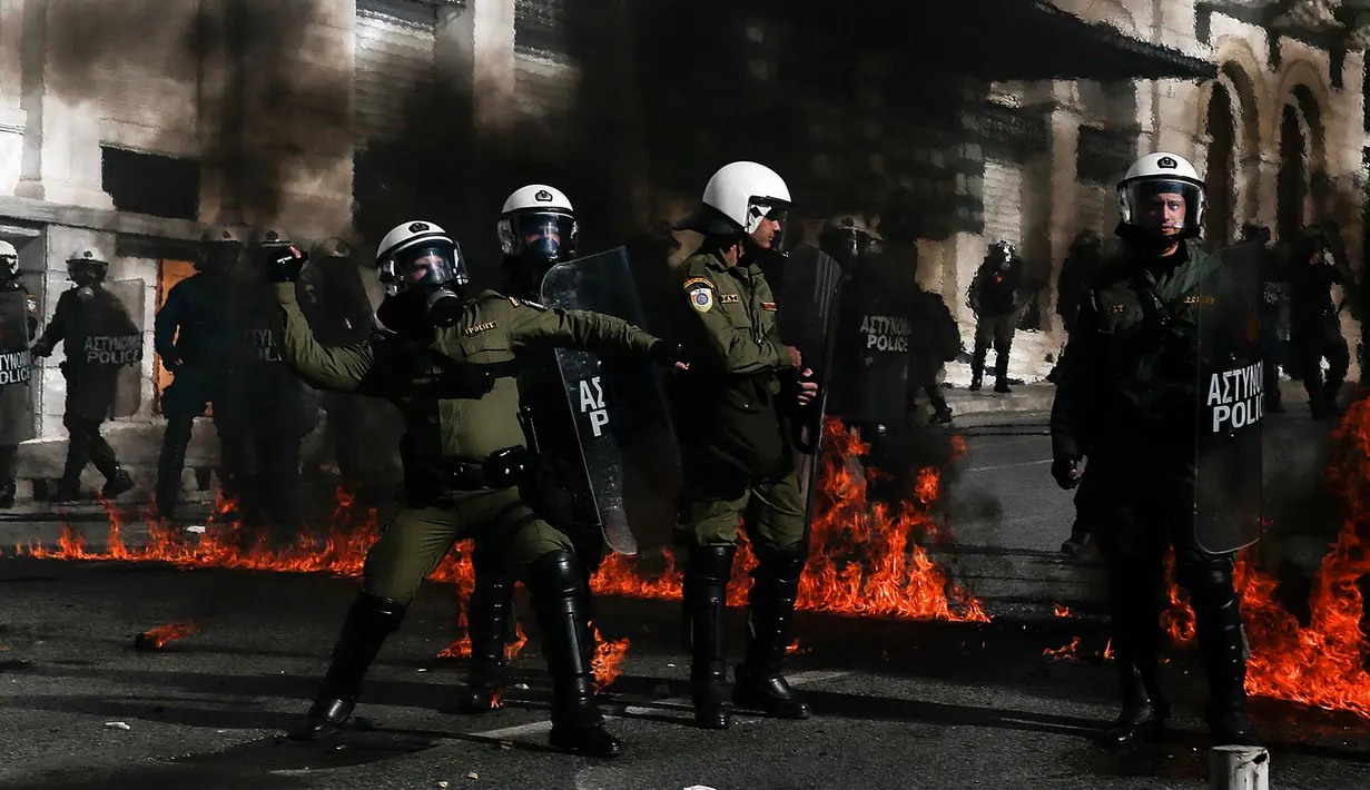 Sejumlah polisi anti huru-hara melawan aksi demonstran yang melemparkan bom api di Athena, Yunani, (12/11/2015). Demonstran melempari para polisi dengan bom api. (REUTERS/Alkis Konstantinidis)