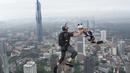 Sepasang pelompat BASE terjun dari Menara Kuala Lumpur selama KL Tower International Jump Malaysia di Kuala Lumpur, Jumat (3/2/2023). Ada yang melompat dengan santai tapi banyak juga yang berpose lucu sambil melompat, bahkan salto selama terjun bebas. (AP Photo/Vincent Thian)