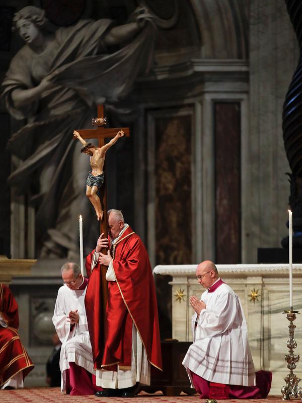 Paus Fransiskus memegang salib ketika prosesi Jumat Agung memperingati penyiksaan Yesus sebelum disalibkan di Basilika Santo Petrus, Vatikan, Jumat (19/4). (AP Photo/Alessandra Tarantino)