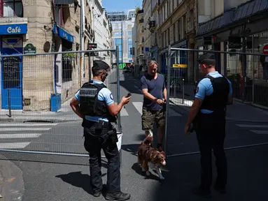 Polisi Prancis mengawasi seorang pejalan kaki di zona akses terbatas di Paris pada 19 Juli 2024. (EMMANUEL DUNAND/AFP)