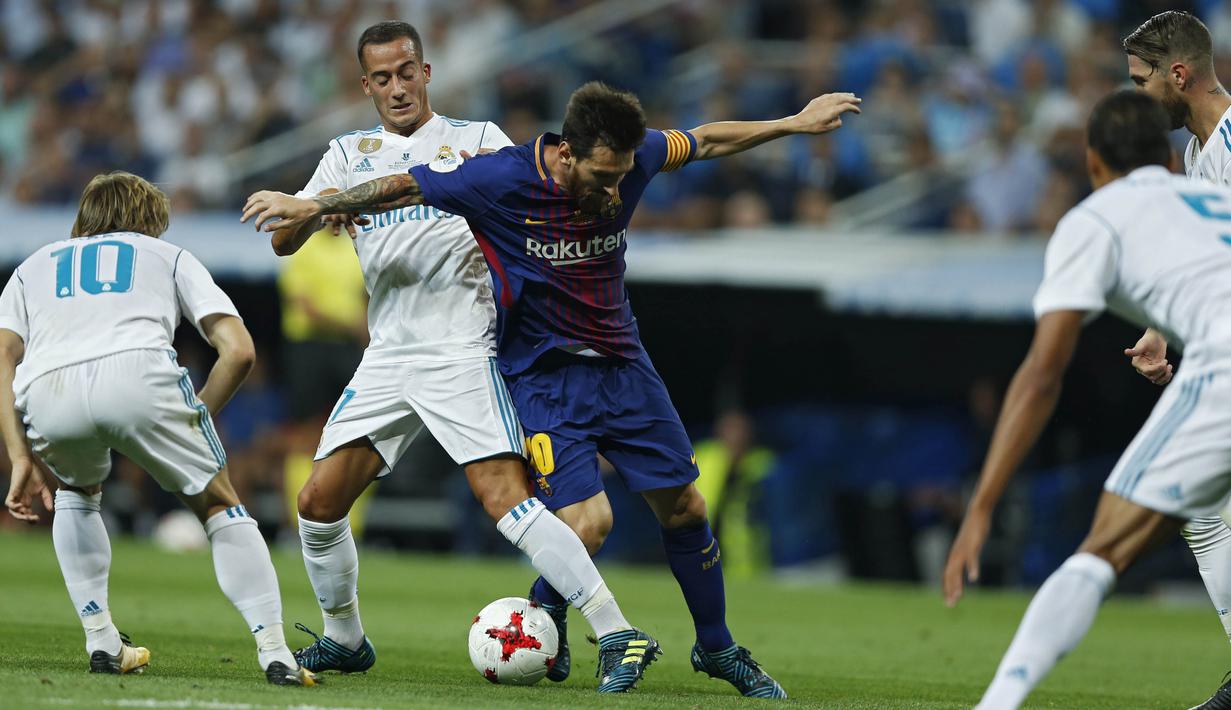 Aksi Lionel Messi (tengah saat mencoba melewati adangan para pemain Real Madrid pada leg kedua Piala Super Spanyol di Santiago Bernabeu stadium (16/8/2017). Real menang 2-0. (AP/Francisco Seco)