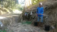 Seorang warga menimba air di aliran sungai lantaran sumurnya mulai mengering. (Foto: Liputan6.com/Muhamad Ridlo).