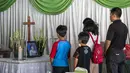 Kerabat memberi penghormatan terakhir kepada Sri Puji, salah satu korban meninggal dalam serangan Gereja Pantekosta, Surabaya, Jawa Timur, Senin (14/5). Serangan bom yang melanda tiga gereja di Surabaya menewaskan belasan orang. (AFP PHOTO/JUNI KRISWANTO)