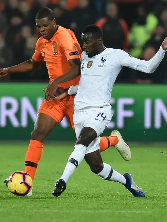 Gelandang Prancis, Blaise Matuidi berusaha mengumpan bola dari kawalan bek Belanda, Denzel Dumfries selama pertandingan UEFA Nations League di stadion Feijenoord di Rotterdam (16/11). Belanda menang atas Prancis 2-0. (AFP Photo/John Thys)