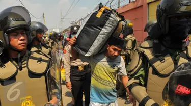 Petugas Satpol PP dan anggota Kepolisian saat menjaga evakuasi warga Tanah Tinggi, Tangerang, Selasa, (14/3). Pemprov Kota Tangerang membongkar rumah warga Tanah Tinggi karena tak memiliki surat ijin tinggal yang resmi. (Liputan6.com/Faisal R Syam)