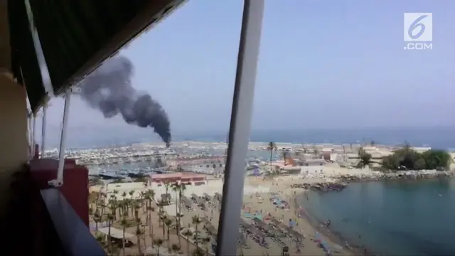 Asap hitam terlihat dari api kapal di Fuengirola, Spanyol.