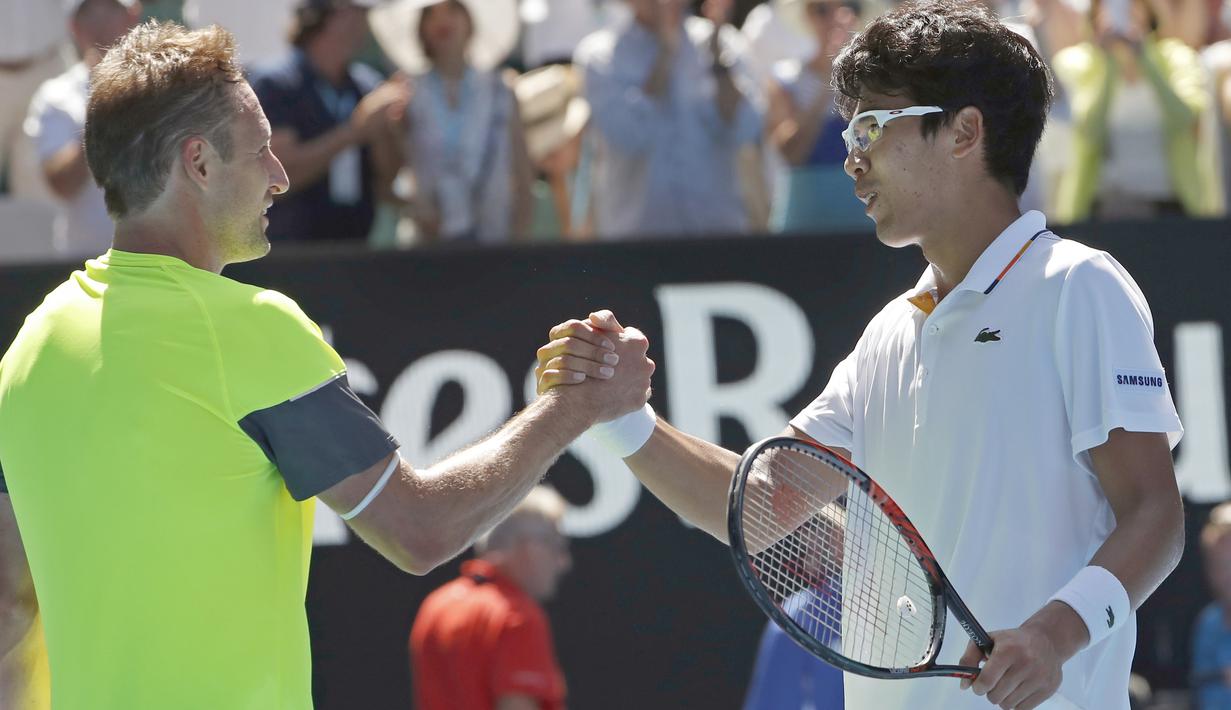 Chung Hyeon (kanan) memberi salam kepada Tennys Sandgren usai laga perempat final Australia Terbuka 2018 di Melbourne, Australia, (24/1/2018). Chung menang 6-4, 7-6, 6-3. (AP/Ng Han Guan)