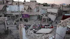 Suasana buka bersama Warga Suriah di tengah reruntuhan bangunan saat bulan suci Ramadan di Kota Douma yang dikuasai pemberontak di pinggiran ibukota Damaskus, Suriah, (18/6). (AFP Photo/Hamza Al-Ajweh)