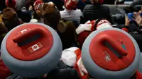 Penonton mengenakan atribut kepala unik saat menyaksikan cabang curling ganda campuran antara Kanada dan Swiss pada Olimpiade Musim Dingin 2018 di Gangneung, Korsel, Selasa (13/2). Olimpiade ini berlangsung hingga 25 Februari mendatang. (AP/Aaron Favila)