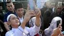 Seorang warga berselfie dengan Presiden Joko Widodo usai melaksanakan salat id Hari Raya Idul Fitri 1 Syawal 1439 H di Lapangan Astrid, Kebun Raya Bogor, Jumat (15/6). (Merdeka.com/Arie Basuki)