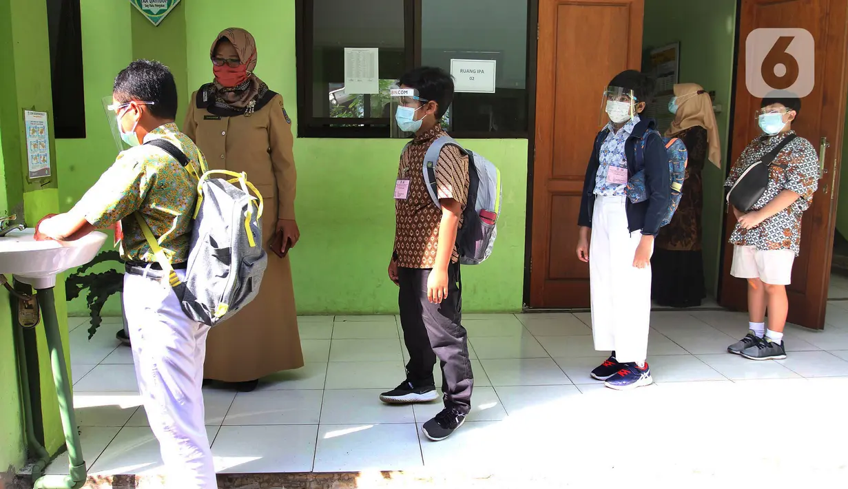 Murid mencuci tangan sebelum mengikuti kegiatan Kompetisi Sains Nasional (KSN) seleksi Tingkat SD/ MI se-Kota Depok mata pelajaran IPA di SDN Kemirimuka 3, Depok, jawa Barat, Senin (22/3/2021). Pelaksanaan KSN tahun ini dilaksanakan secara tatap muka. (merdeka.com/Arie Basuki)