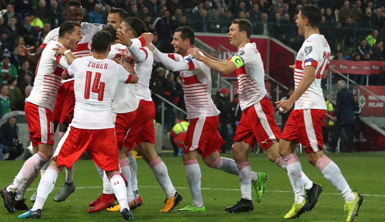 Pemain Swiss merayakan gol rekan setimnya, Ricardo Rodriguez lewat penalti ke gawang Irlandia Utara pada leg pertama playoff Piala Dunia 2018 di Windsor Park, Jumat (10/11). Bermain di kandang lawan, Swiss meraih kemenangan tipis 1-0. (AP/Peter Morrison)