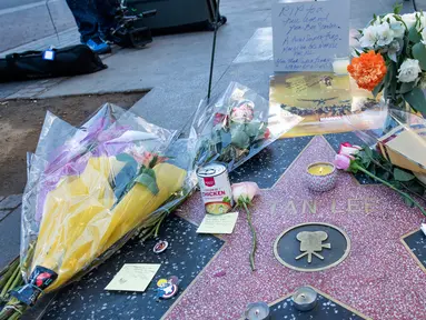 Penggemar meletakkan karangan bunga dan memorabilia lainnya di atas bintang Walk of Fame milik pencipta sekaligus legenda komik-komik Marvel, Stan Lee di Hollywood, California, Senin (12/11). Stan Lee meninggal dunia pada usia 95. (VALERIE MACON / AFP)