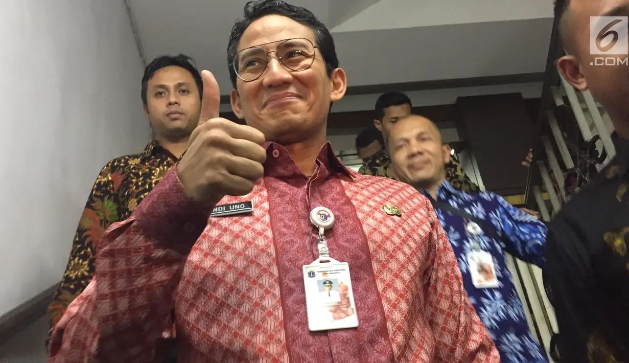 Wakil Gubernur DKI Jakarta Sandiaga Uno mengacungkan jempol sambil meninggalkan Gedung Ditreskrimum Polda Metro Jaya, Kamis (18/11). Sandiaga diperiksa sebagai saksi kasus penipuan dan penggelapan lahan di Curug Tangerang. (Liputan6.com/Immanuel Antonius)