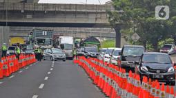 Petugas kepolisian mengatur kendaraan yang melintas di Km 34 B Tol Jakarta - Cikampek (Japek), Cikarang, Sabtu (22/5/2021). Polda Metro Jaya memprediksi puncak arus balik mudik Lebaran ke DKI Jakarta akan terjadi pada akhir pekan ini, 21-23 Mei 2021. (Liputan6.com/Herman Zakharia)